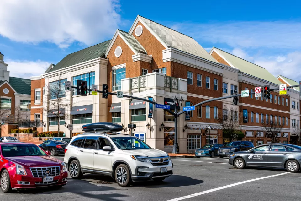 View of intersection in Fairfax, Virginia with three-story building and cars in intersection